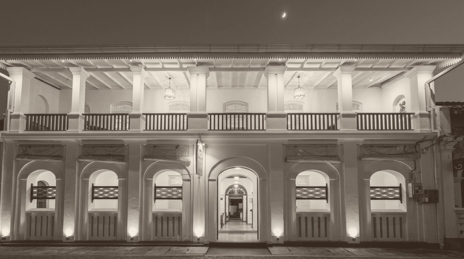 The Zeegolf house at dusk, lanterns lit on the verandah